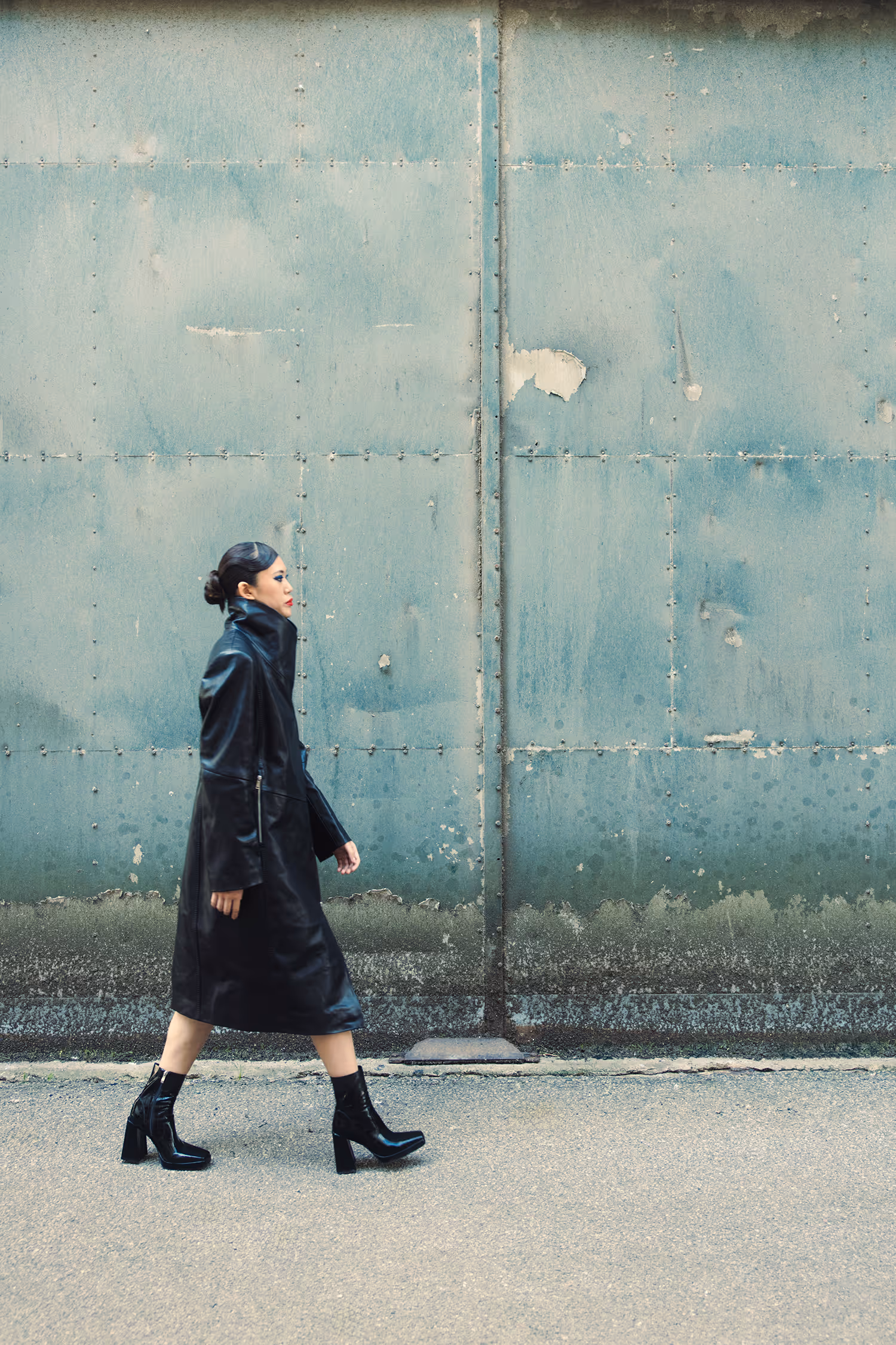 Walking woman against a light blue wall