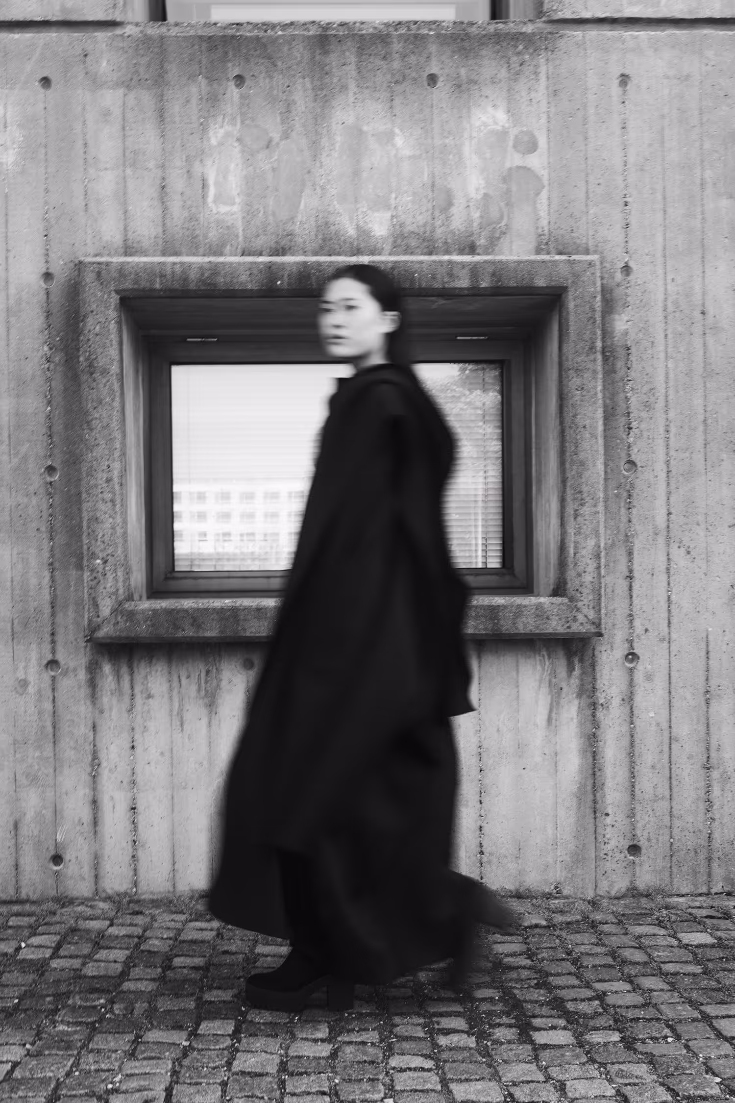 Woman in a black swimsuit walking past a window