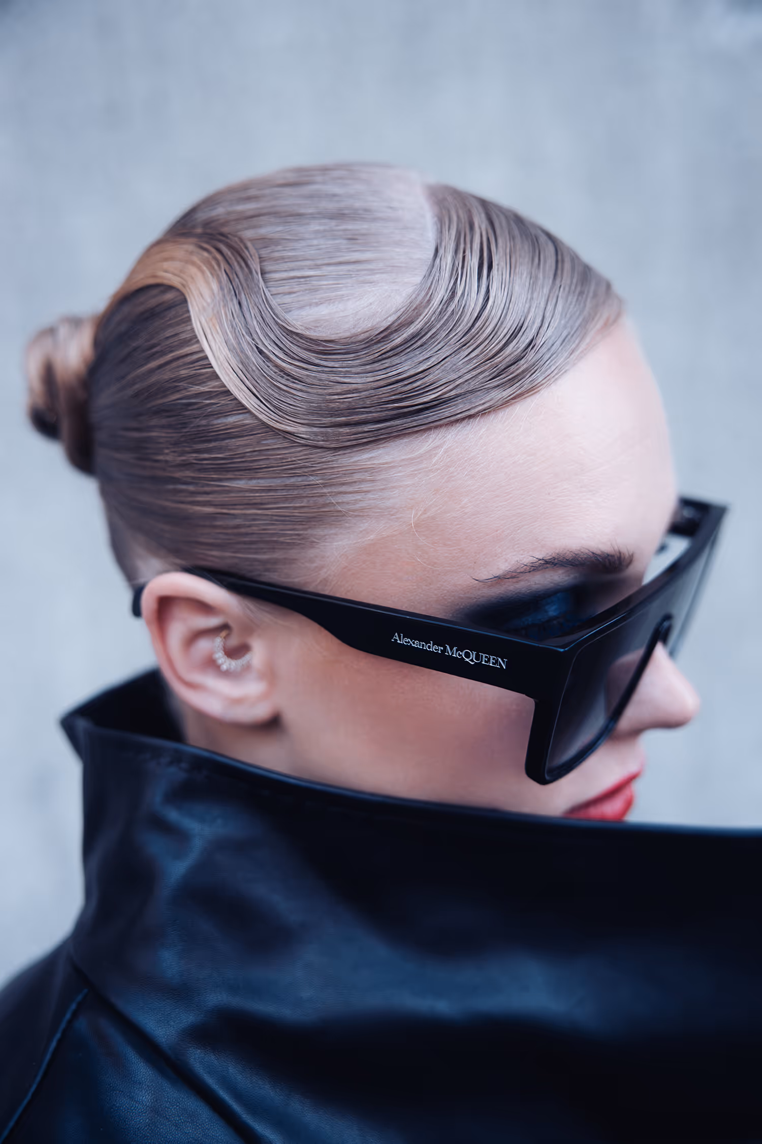 Profile of a woman in sunglasses with a collar covering her chin