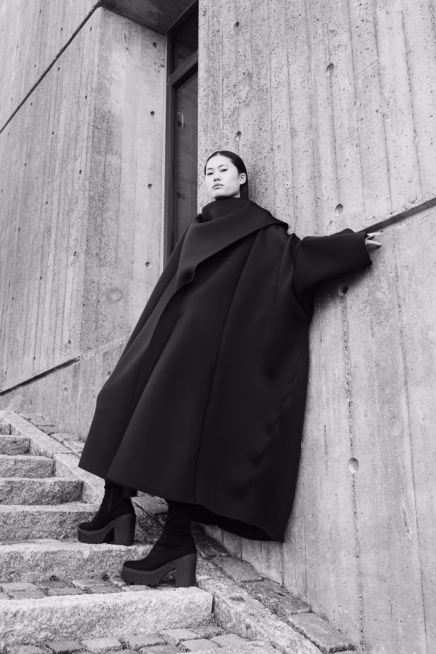 Woman standing on the stairs leaning against the wall